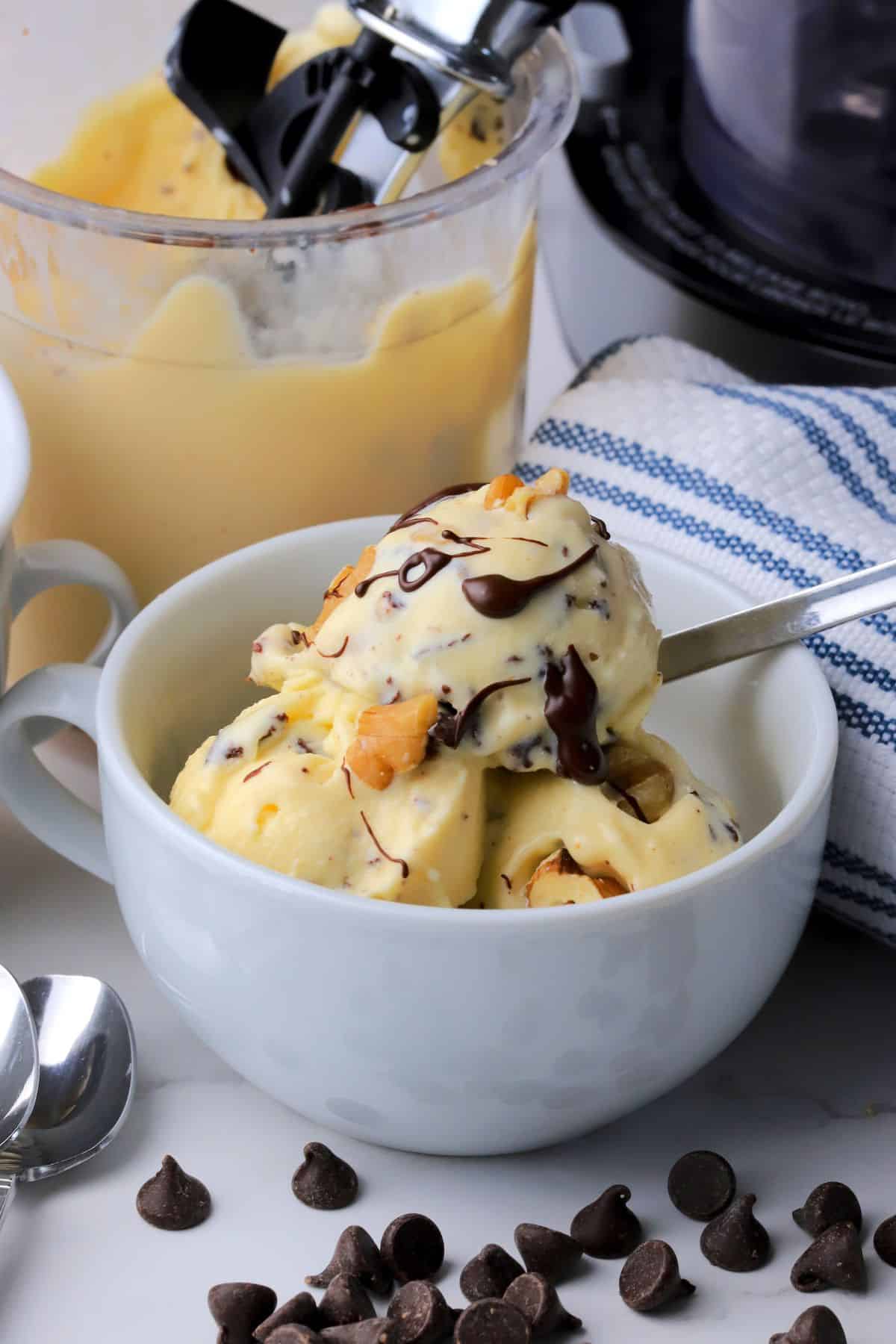 High protein chunky monkey ice cream in a bowl with the ninja creami pint in the background.
