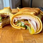2 ingredient cottage cheese wrap on a cutting board rolled and sliced in half.