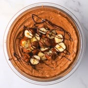 High protein chocolate hazelnut ice cream topped with roasted hazelnuts and chocolate drizzle.