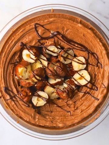 High protein chocolate hazelnut ice cream topped with roasted hazelnuts and chocolate drizzle.