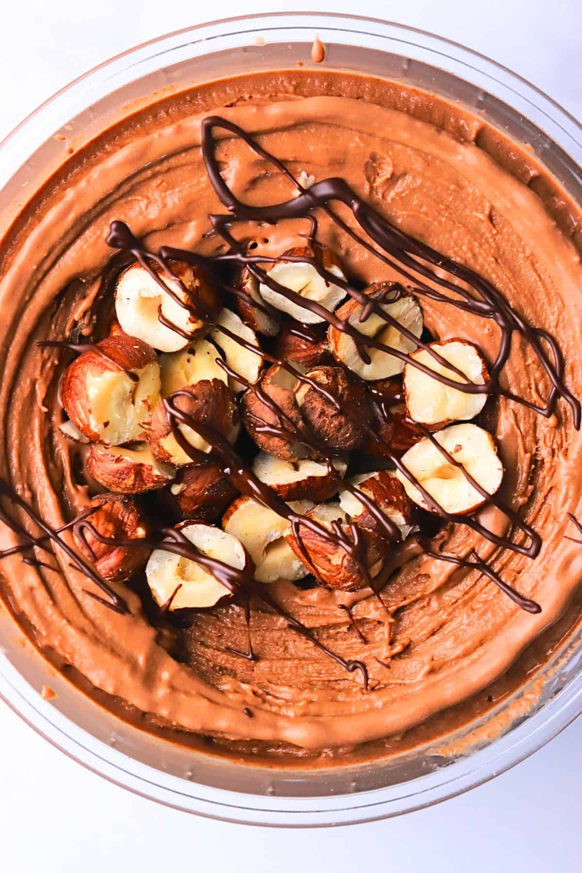 High protein chocolate hazelnut ice cream topped with roasted hazelnuts and chocolate drizzle.