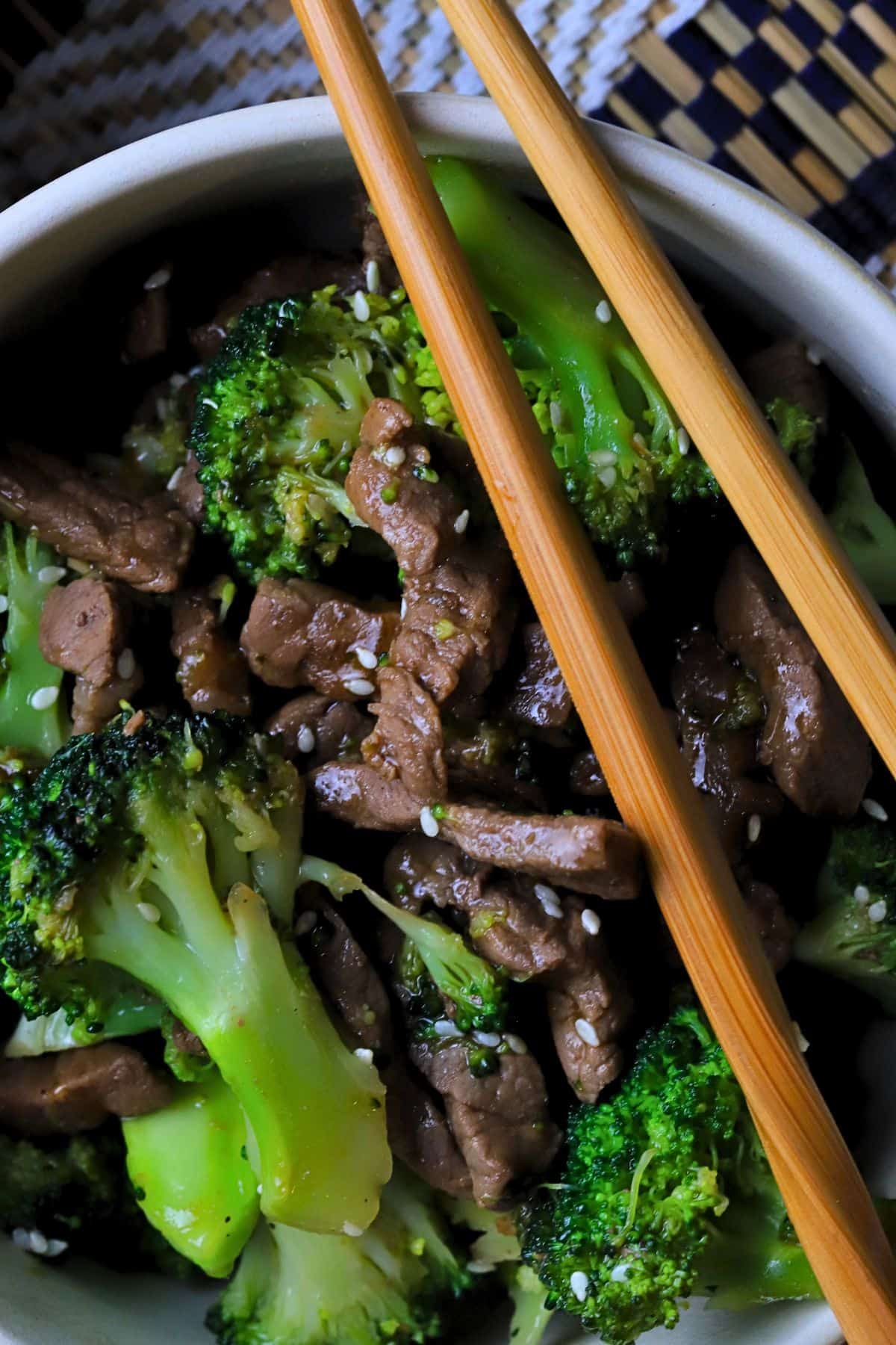 Low carb beef and broccoli in a bowl with chopsticks.
