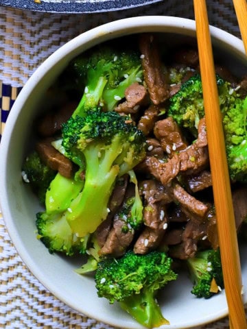 Low carb beef and broccoli in a bowl with chopsticks.