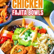 Low carb chicken fajita bowl filled with chicken, peppers, black beans, tomatoes, cauliflower rice and an avocado.