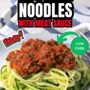 Zucchini noodles on a plate topped with a meat sauce.