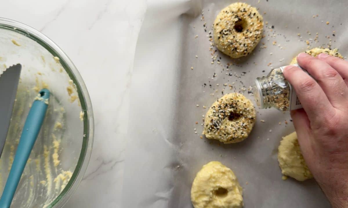 Sprinkling the everything but the bagel seasoning on to the low carb bagels.