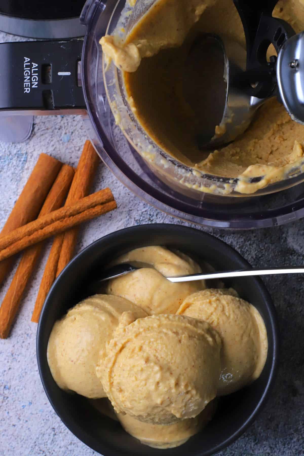 Chickpea cinnamon ice cream in a bowl next to the ninja creami pint.