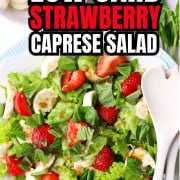 The low carb strawberry caprese salad on a plate next to a bowl of strawberries and basil pin.