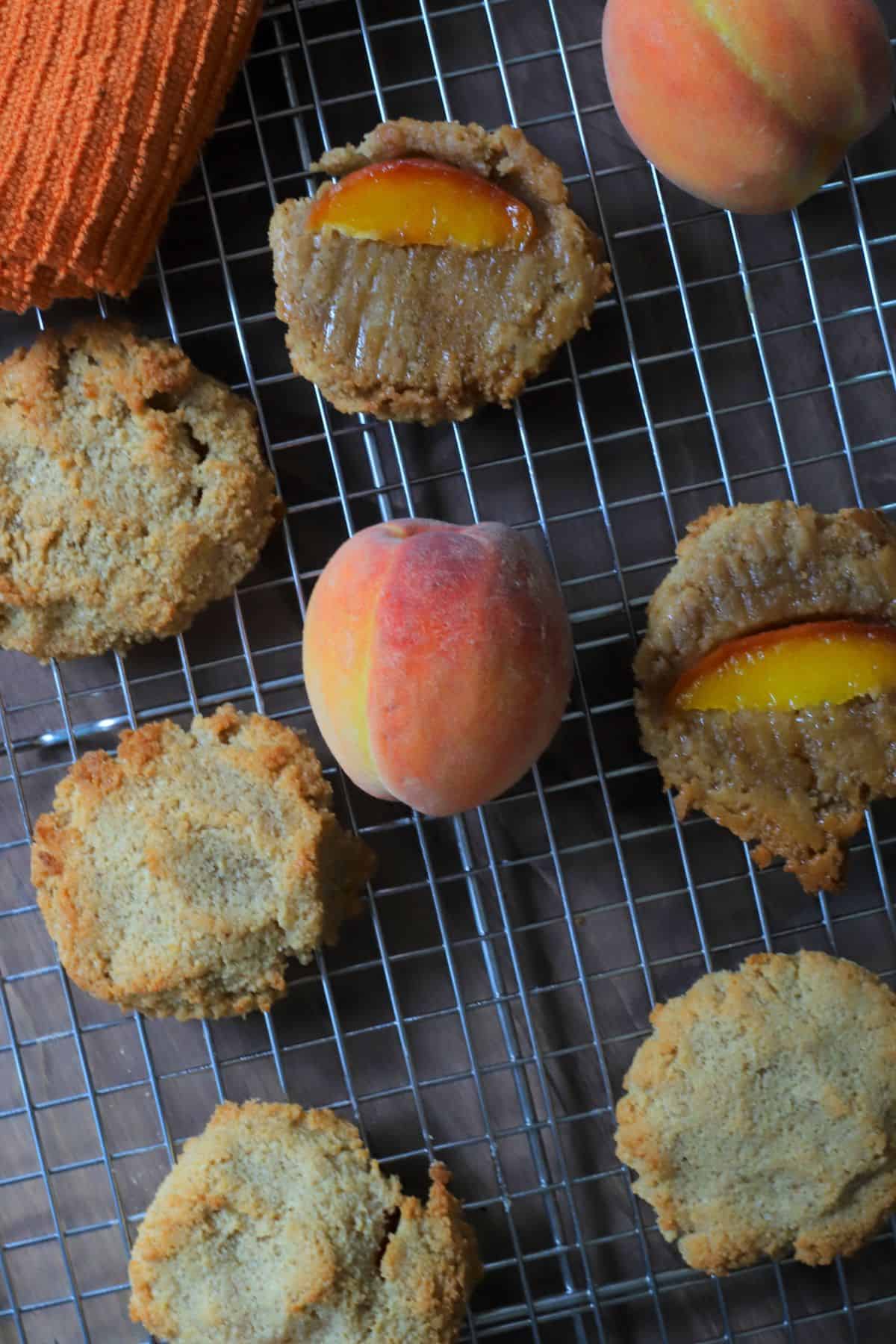 Low carb peach upside down cookies on a cooling rack with peaches.