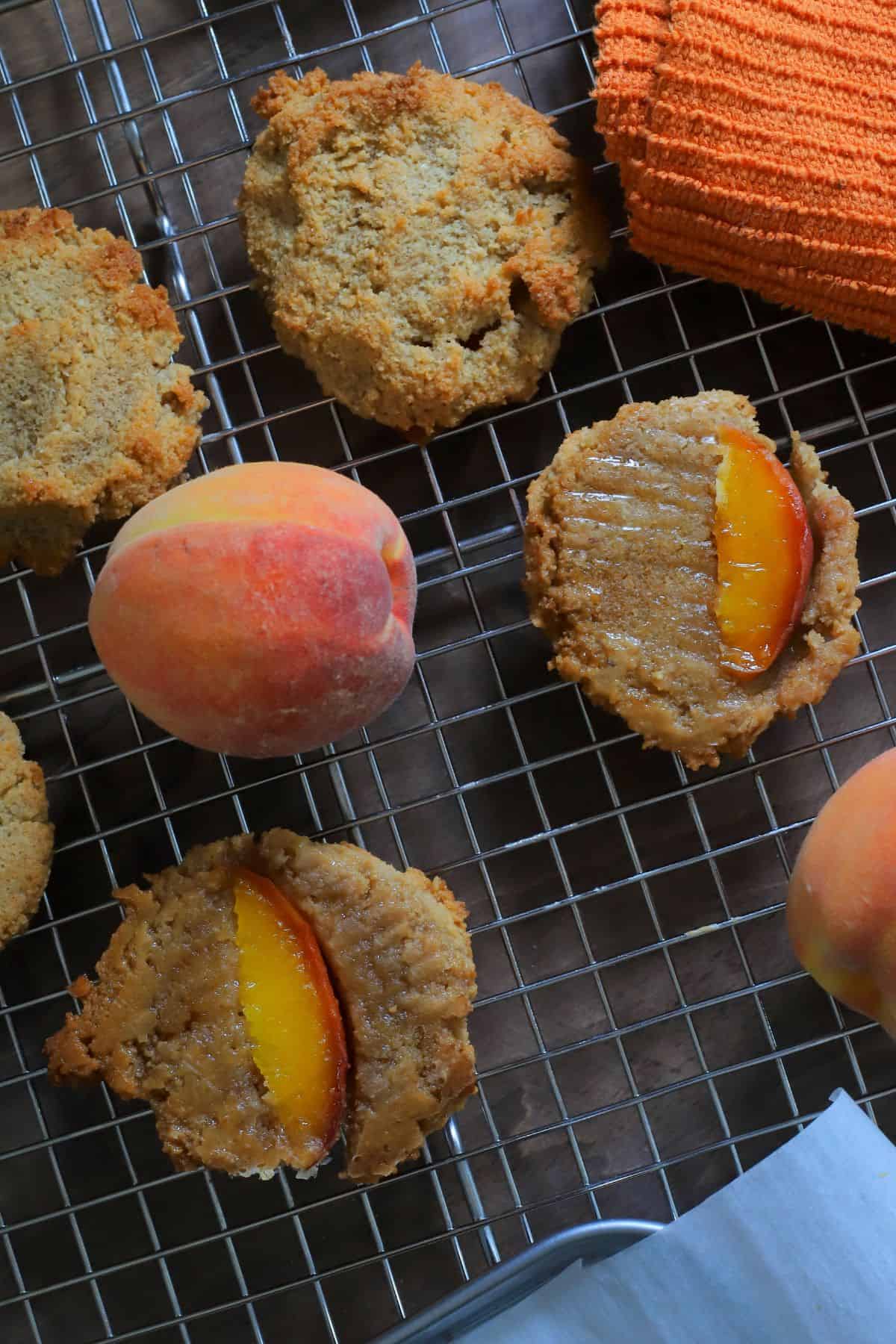 Low carb peach upside down cookies on a cooling rack with peaches.