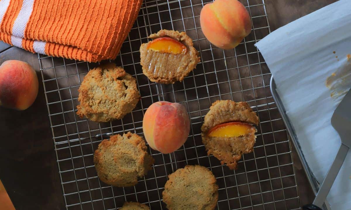 Low carb peach upside down cookies on a cooling rack with peaches.
