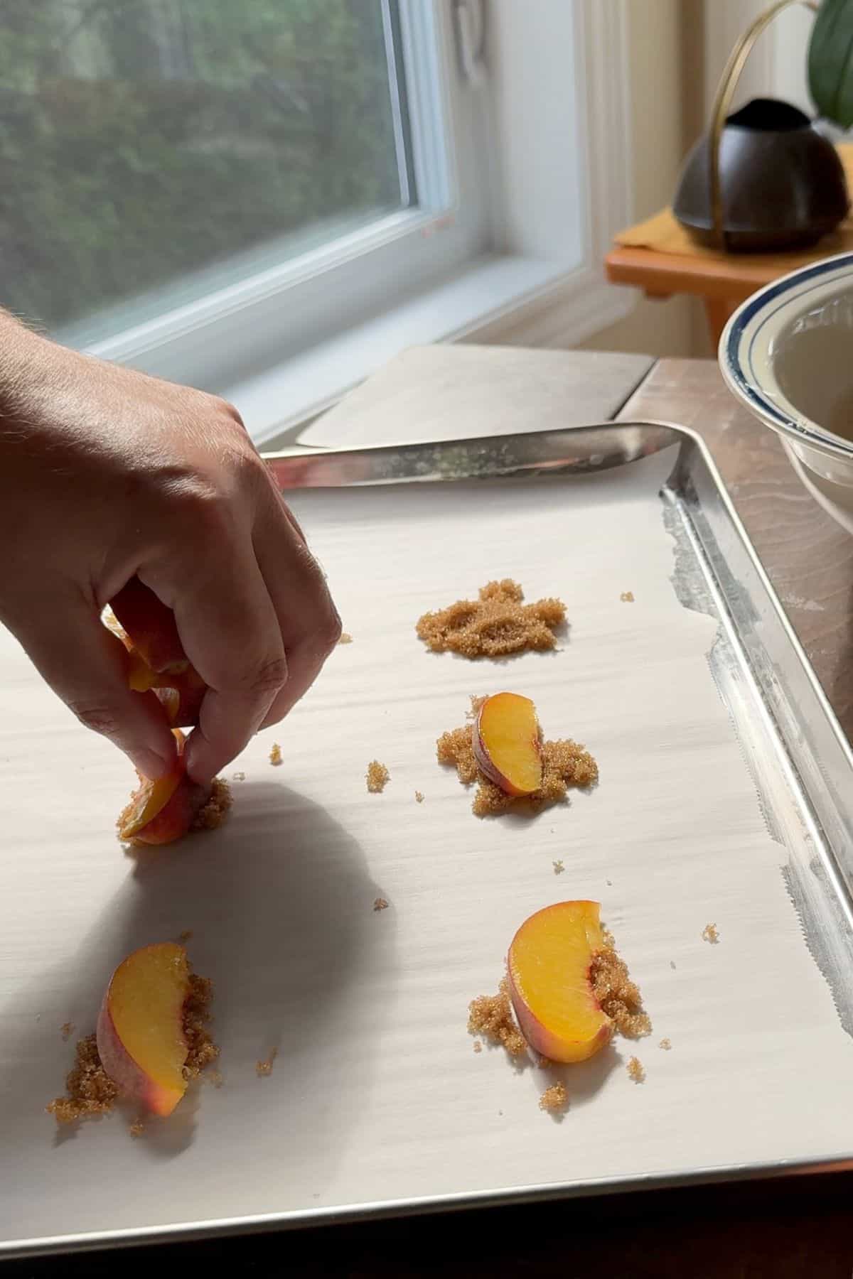 Topping the brown sweetener with peach slices.