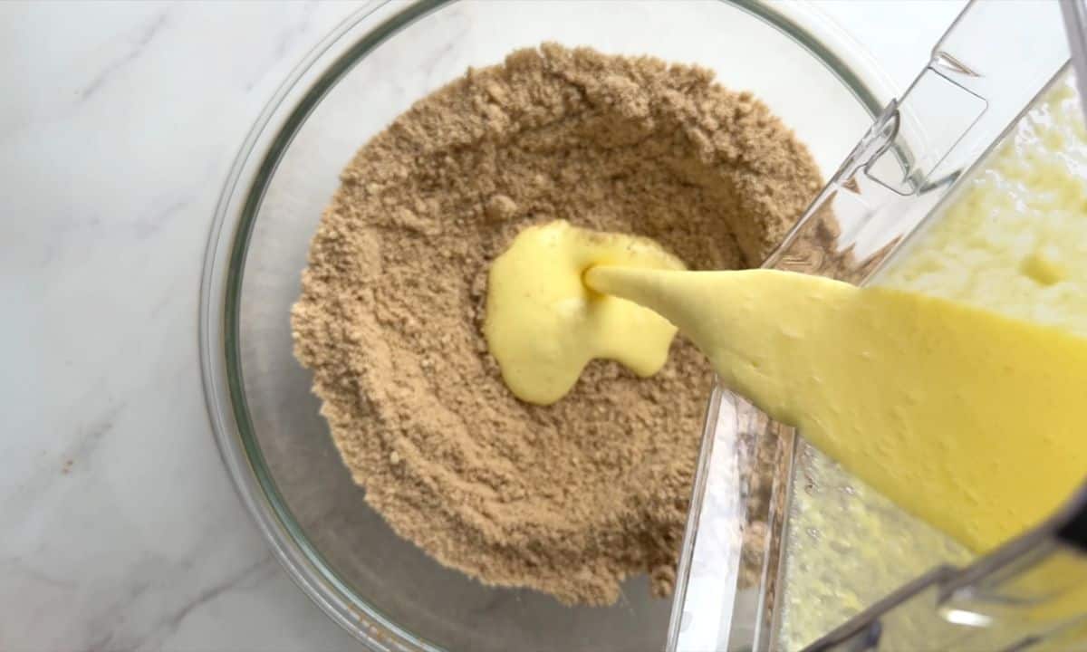 Pouring the wet ingredients onto the dry ingredients in a bowl.