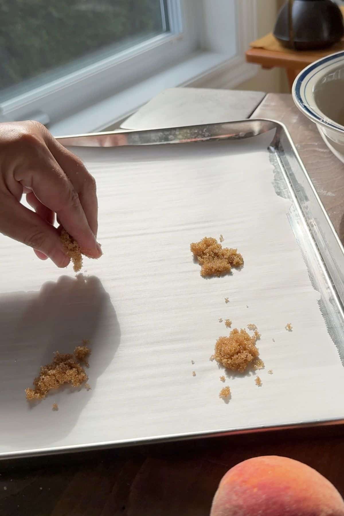 Sprinkling the brown sweetener onto the parchment lined baking sheet.