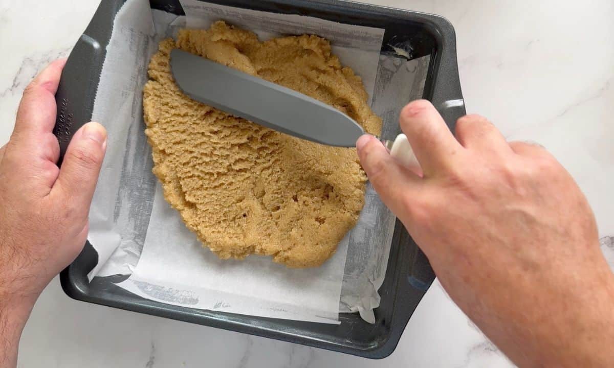 Spreading the crust into the bottom of the baking pan.