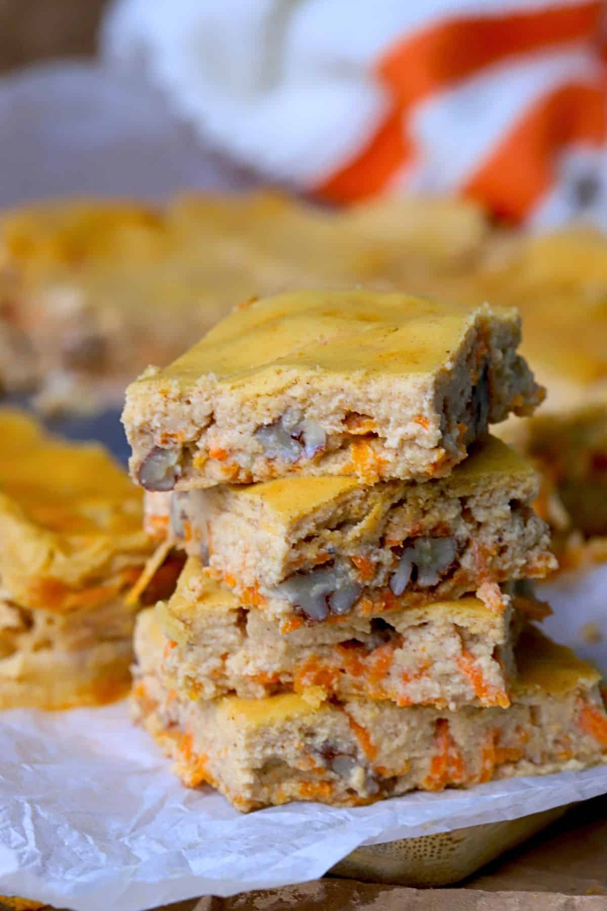 Cottage cheese carrot cake bars stacked on top of each other.