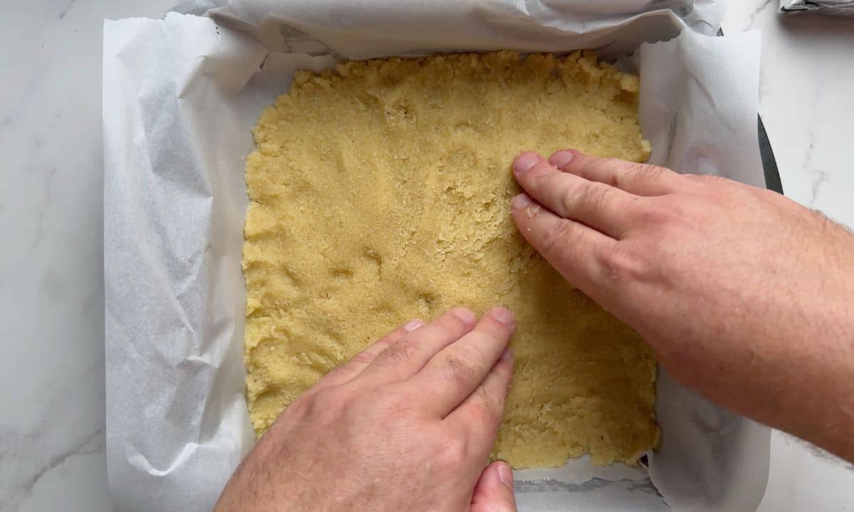 Pressing the crust into the pan.