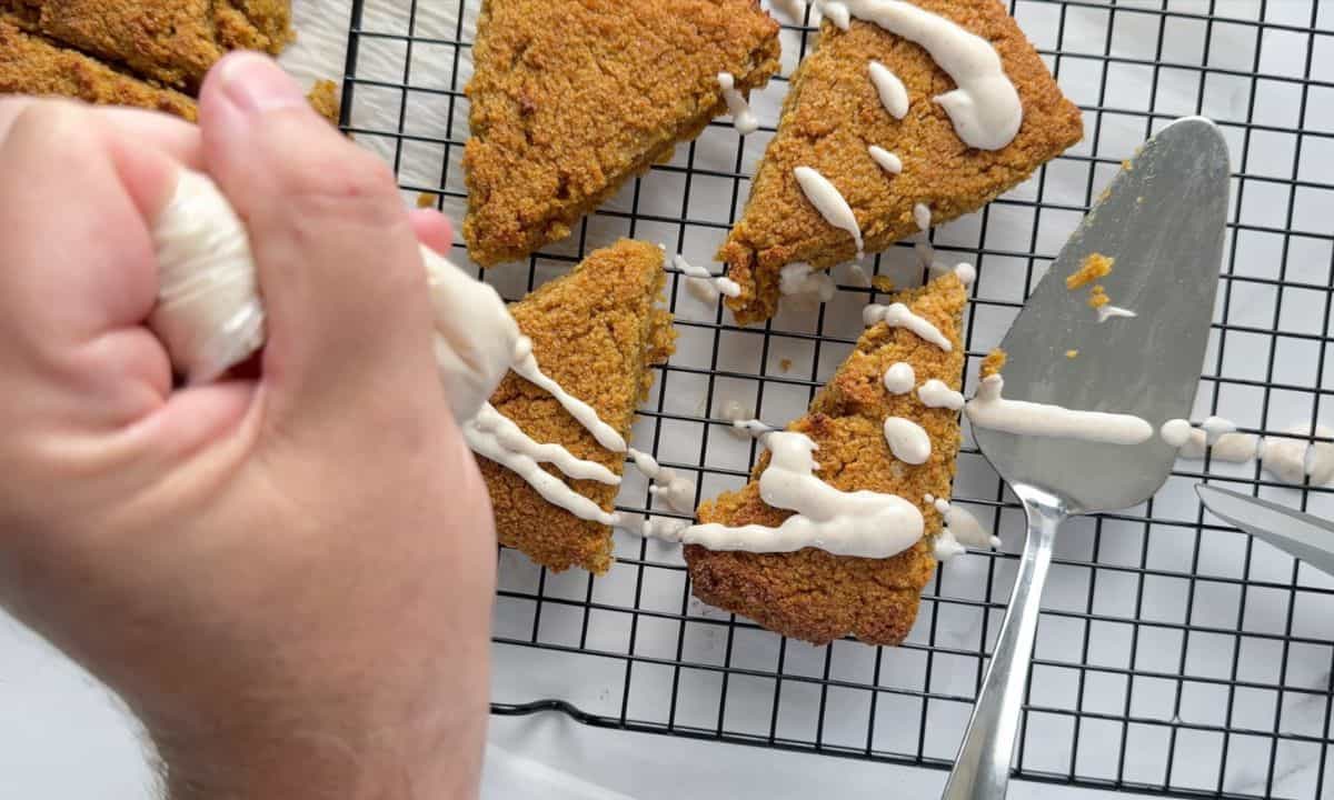 Drizzling the glaze over the Gluten Free High Protein Low carb pumpkin spice scones.
