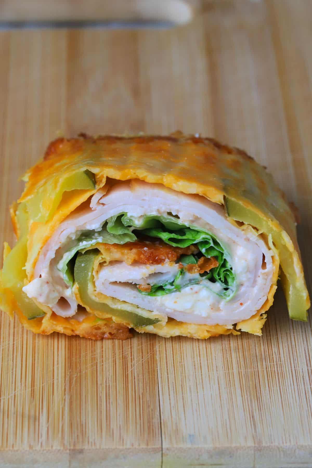 Low carb viral pickle sandwich wrap on a cutting board.