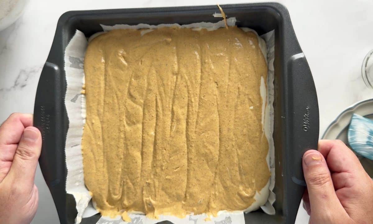 Low carb pumpkin spice cheesecake in the baking pan ready for the oven.