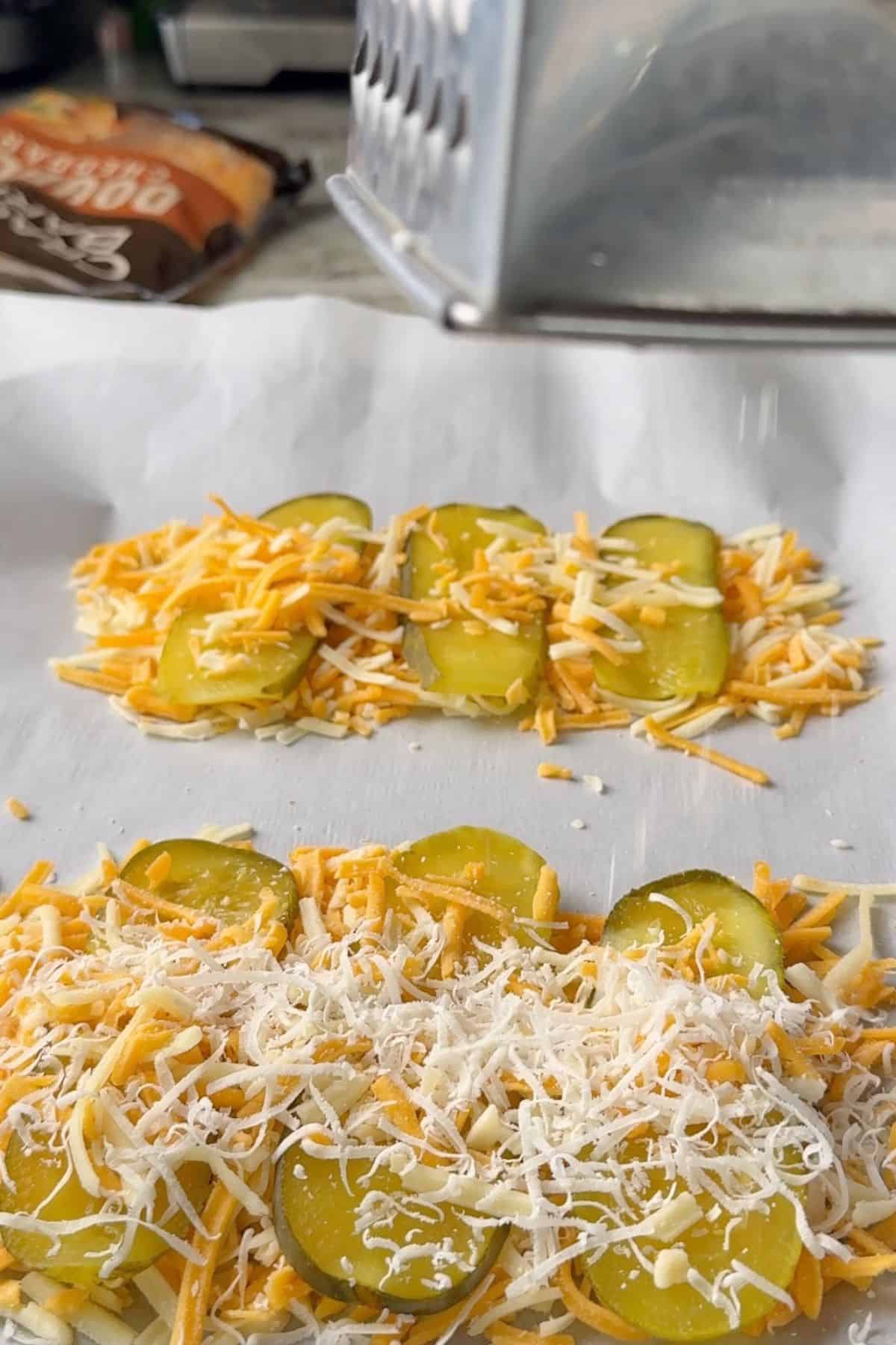 Shredding cheese onto the pickles.