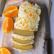 Low carb orange loaf cake cut into slices next to oranges.