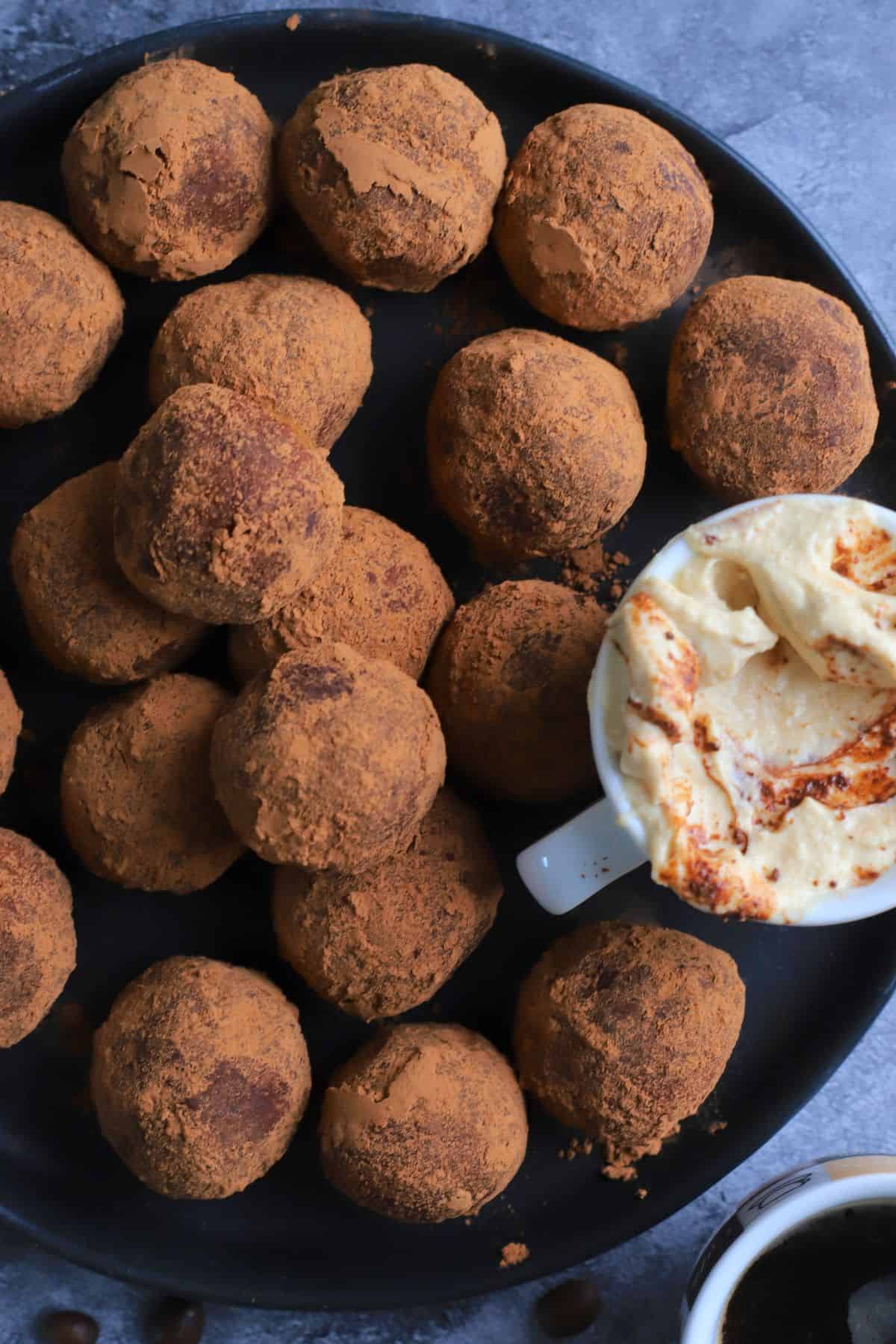 Low carb tiramisu protein balls on a plate next to the dip.