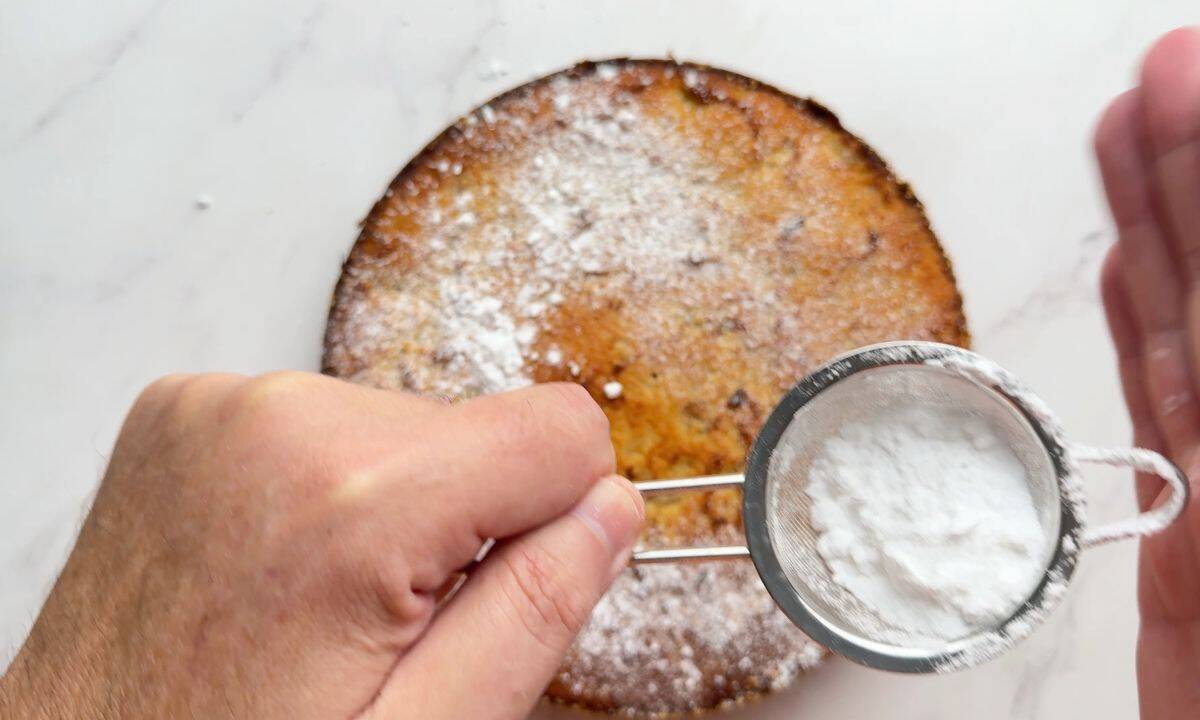 Spinkling powdered sweetener over the cake.