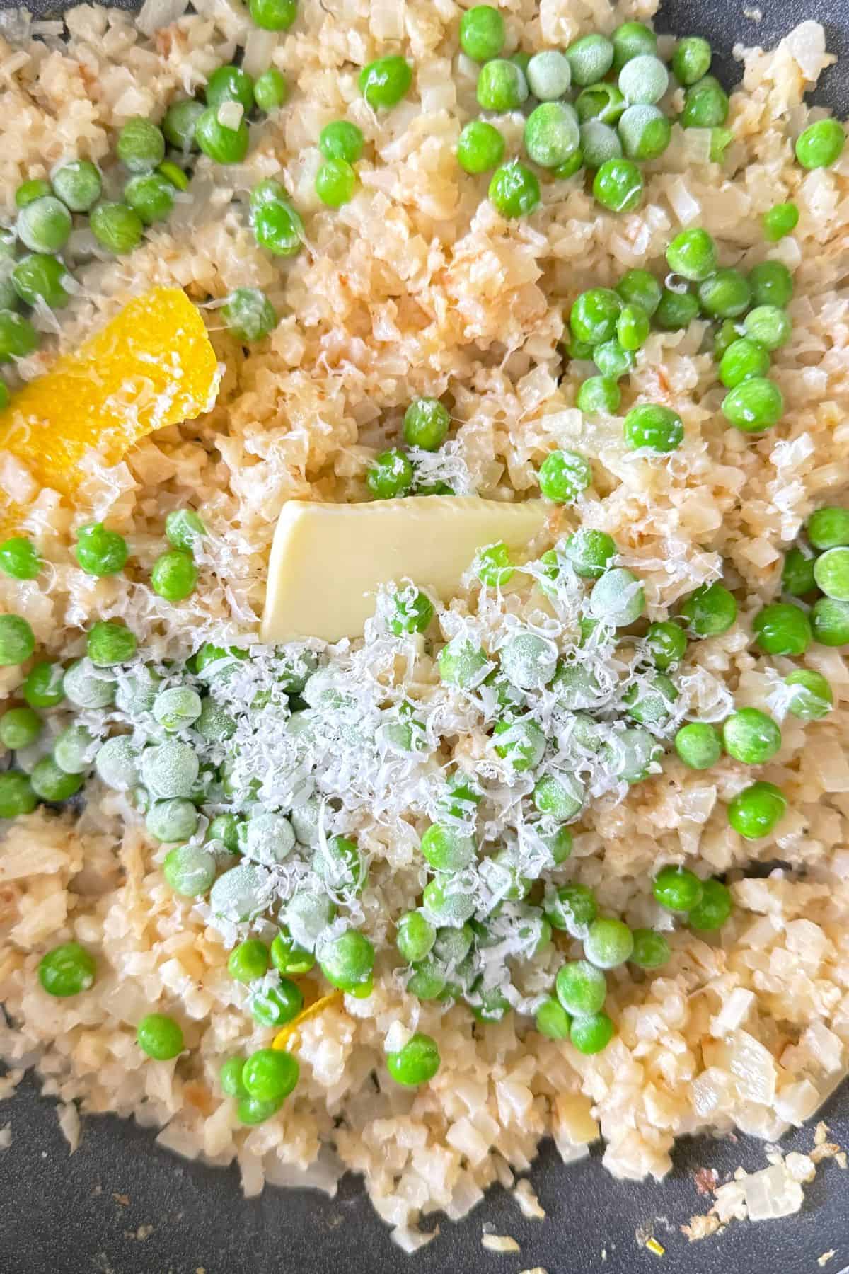 Lemon risotto with the lemon rinds, peas and parmesan in the pan with butter.