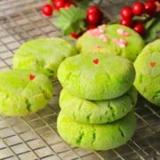 Low carb grinch cookies stacked on a cooling rack.