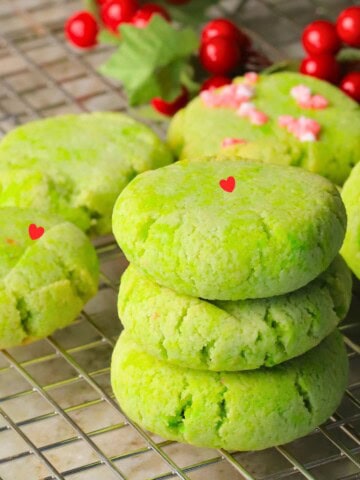 Low carb grinch cookies stacked on a cooling rack.