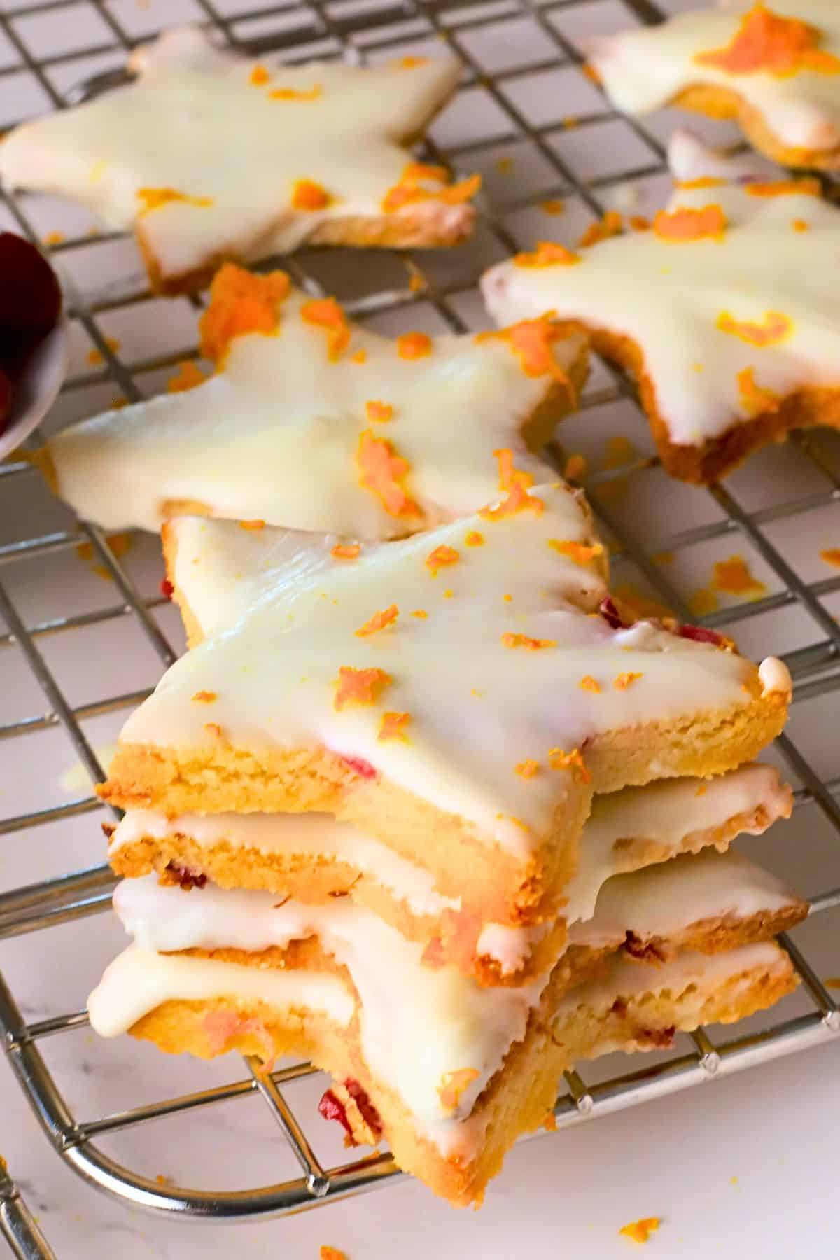 Low carb orange cranberry shortbread cookies stacked on a cooling rack.