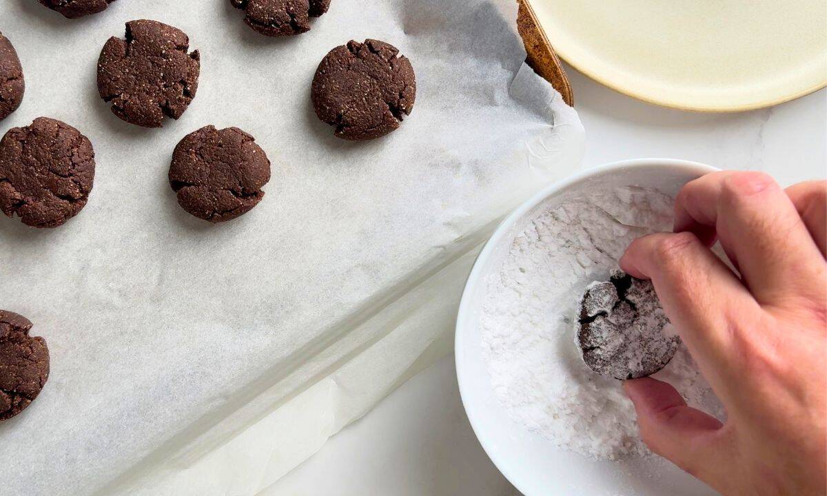 Dipping a cookie in the powdered sweetener.