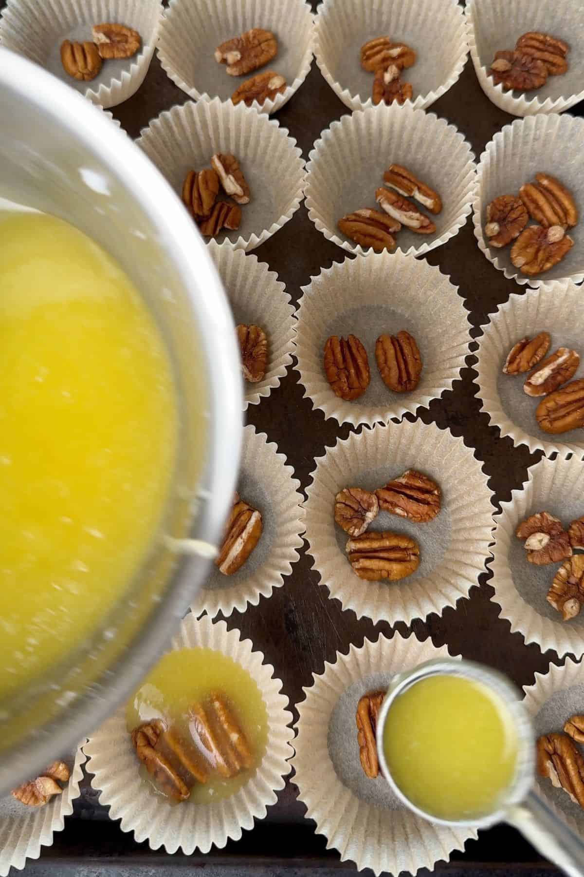 Pouring the sweetened melted butter on top of the pecans.