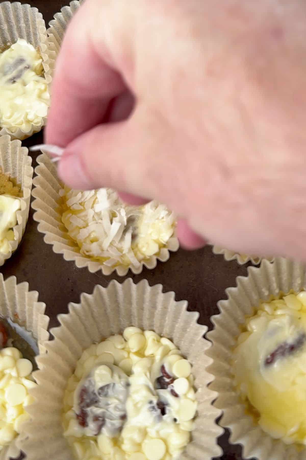 Adding the coconut flakes on top of the melted sugar free white chocolate.