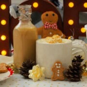 Homemade low carb gingerbread coffee creamer in a bottle next to a mug and other gingerbread men.