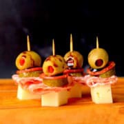 Italian sub skewers with a balsamic olive oil drizzle on a cutting board.