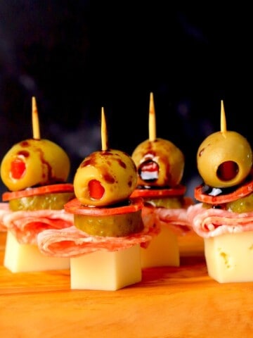 Italian sub skewers with a balsamic olive oil drizzle on a cutting board.