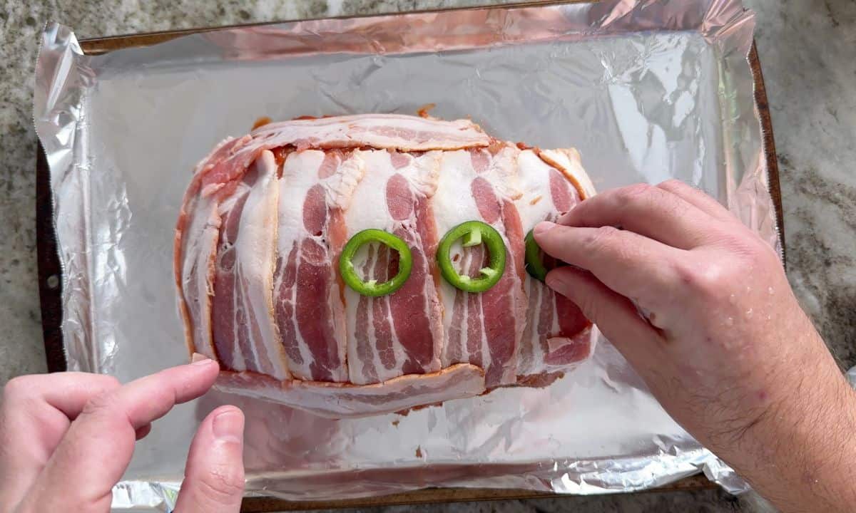 Topping the meatloaf with the sliced jalapenos.