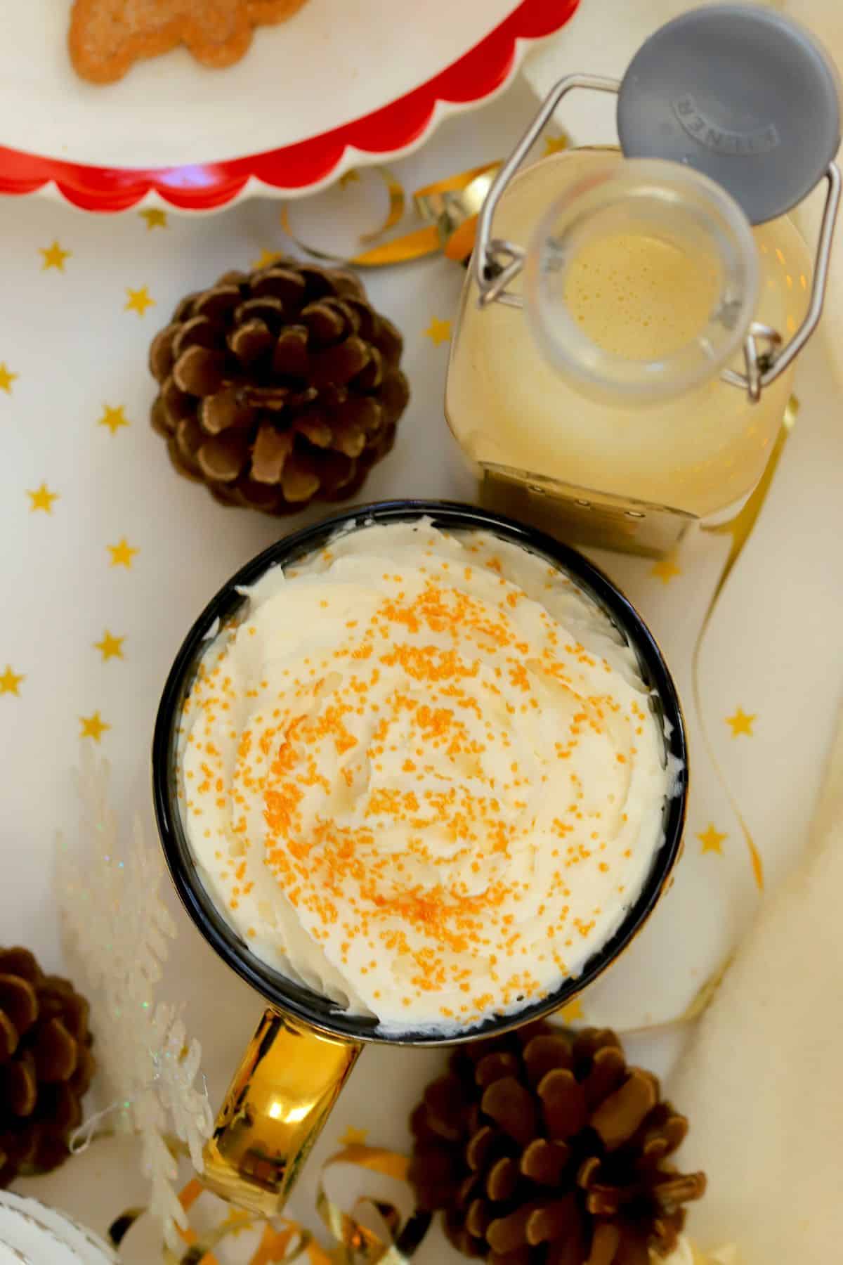 Low carb eggnog coffee creamer in a mug next to a bottle of the dairy free creamer.