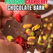 Holding a piece of the low carb pistachio cranberry chocolate bark.
