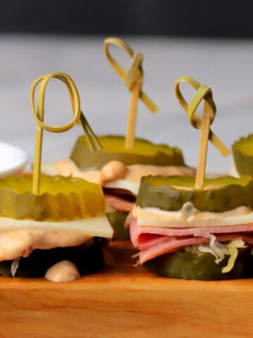 Low carb reuben pickle bites on a cutting board.