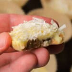 Holding a low carb white chocolate pecan coconut cluster.