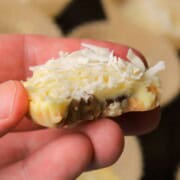 Holding a low carb white chocolate pecan coconut cluster.