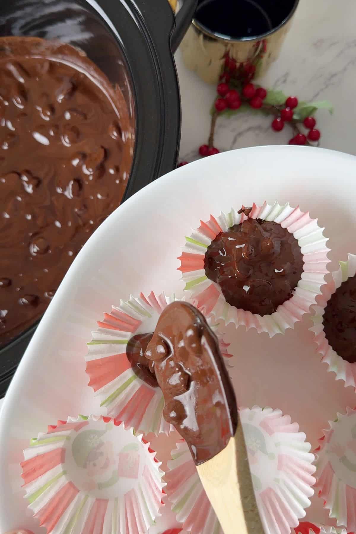 Spooning the melted chocolate into muffin liners.