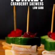 Pinterest pin of the turkey cranberry skewers appetizers on a cutting board.