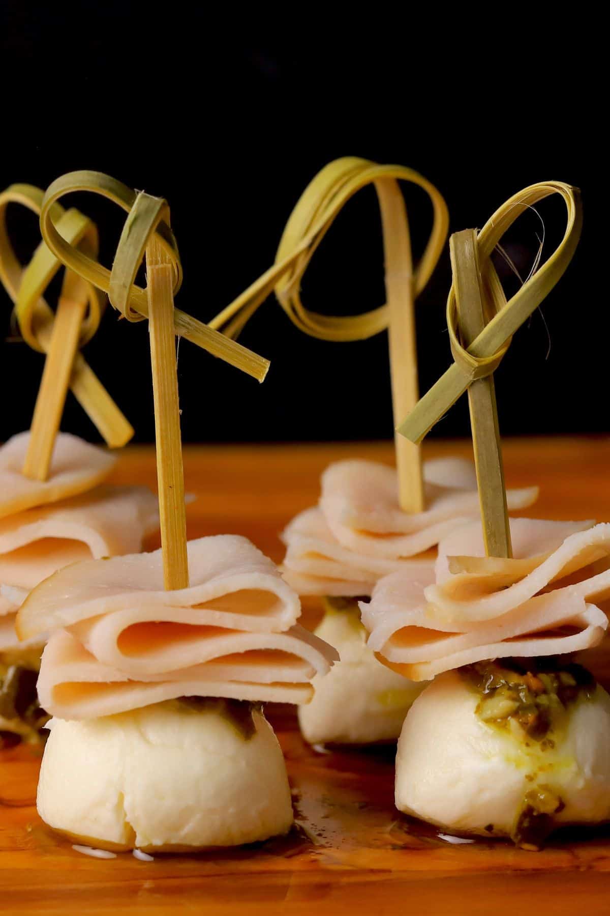 Turkey pesto appetizer skewers on a cutting board.