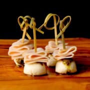 Turkey pesto appetizer skewers on a cutting board.