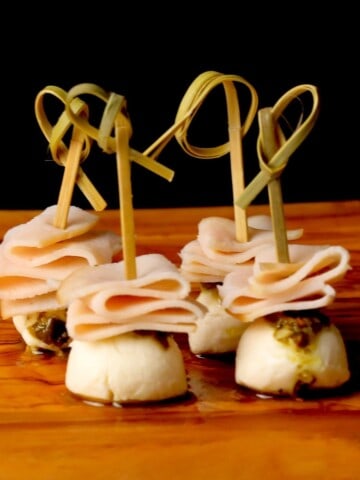 Turkey pesto appetizer skewers on a cutting board.