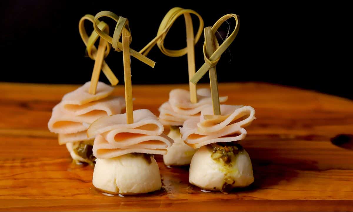 Turkey pesto appetizer skewers on a cutting board.